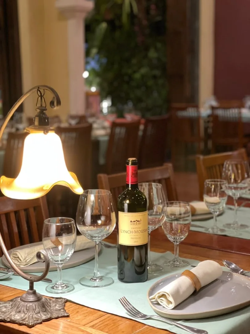 Une table de la maison dressée avec du vin et des verres.